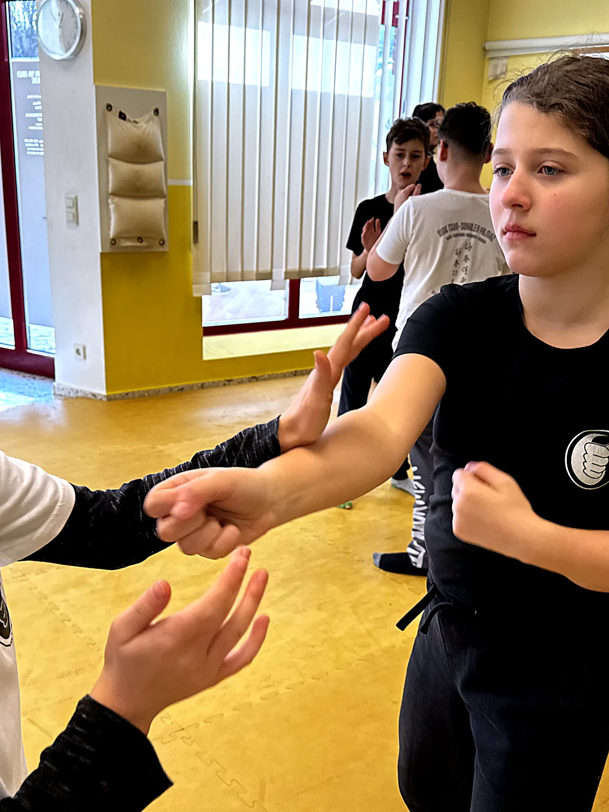 Zwei Jugendliche üben im Armkontakt eine Ving-Tsun-Bewegung