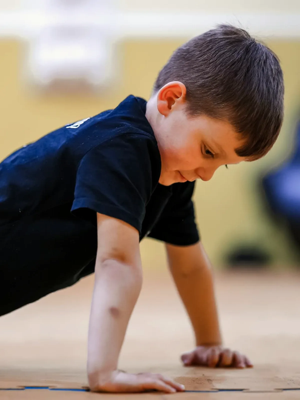 Junge macht konzentriert Liegestütze im Kindertraining