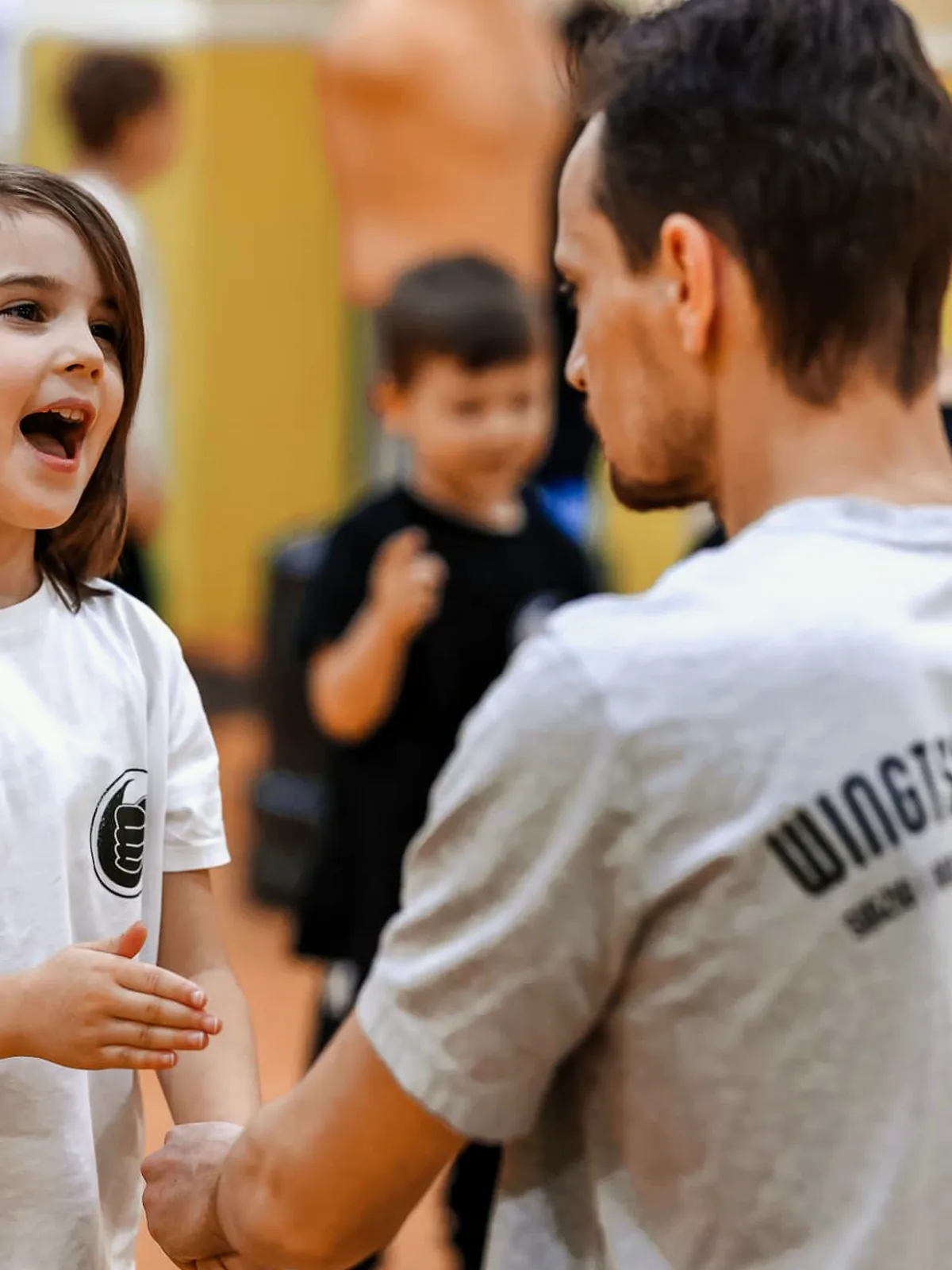 Mädchen lacht im Gespräch mit dem Trainer