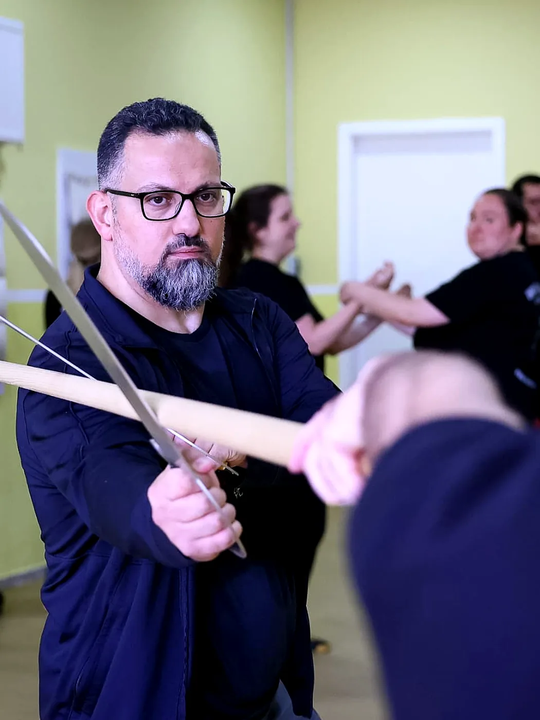 Sifu Levent Yilmaz übt eine Waffenform mit Doppelmessern gegen den Langstock