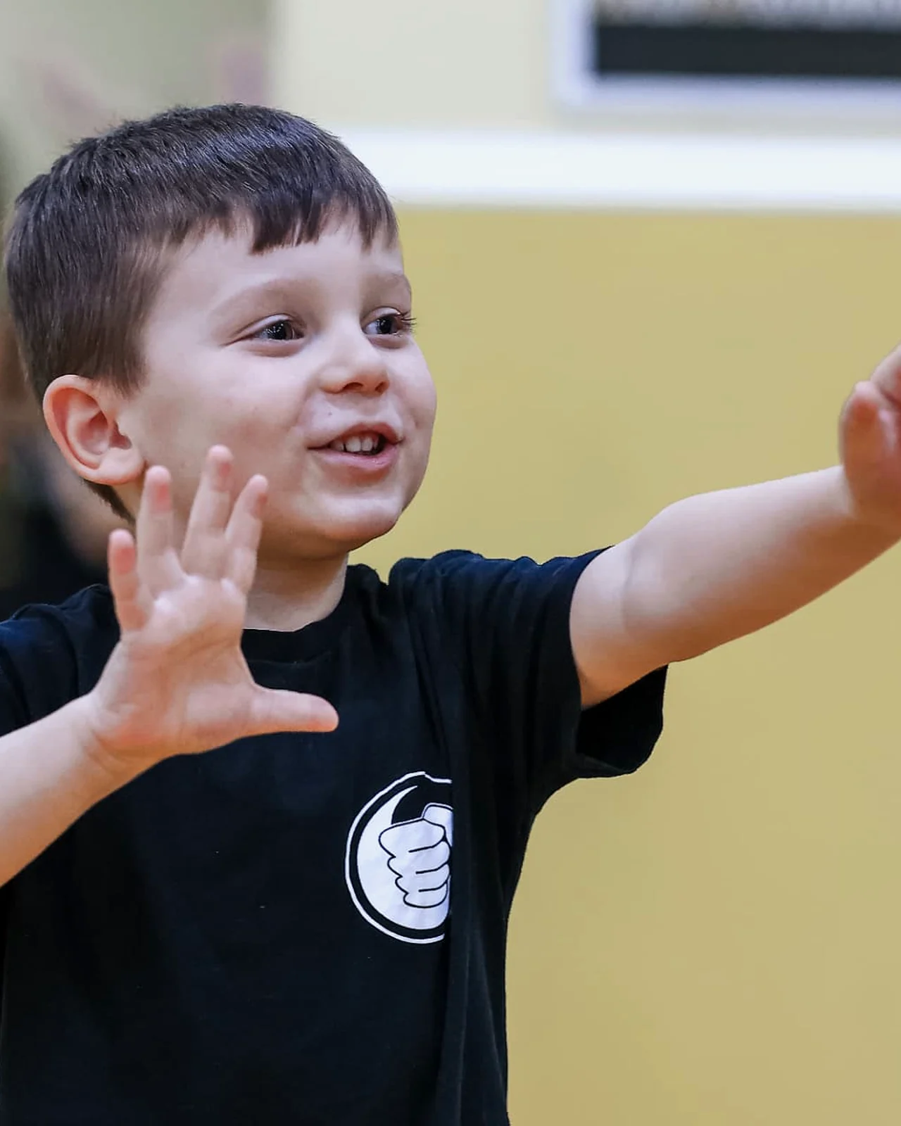 Kind zeigt lachend die Stopp-Handhaltung im Kinder-Ving-Tsun-Training