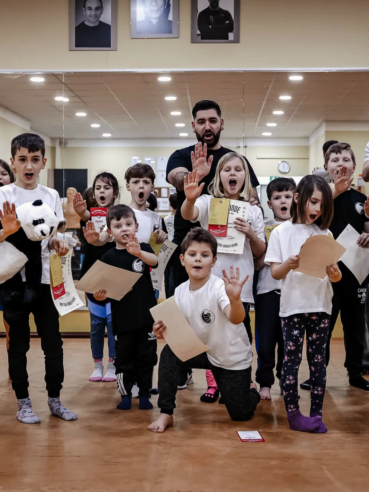 Kindergruppe zeigt nach der Prüfung Urkunden und die Stopp-Hand